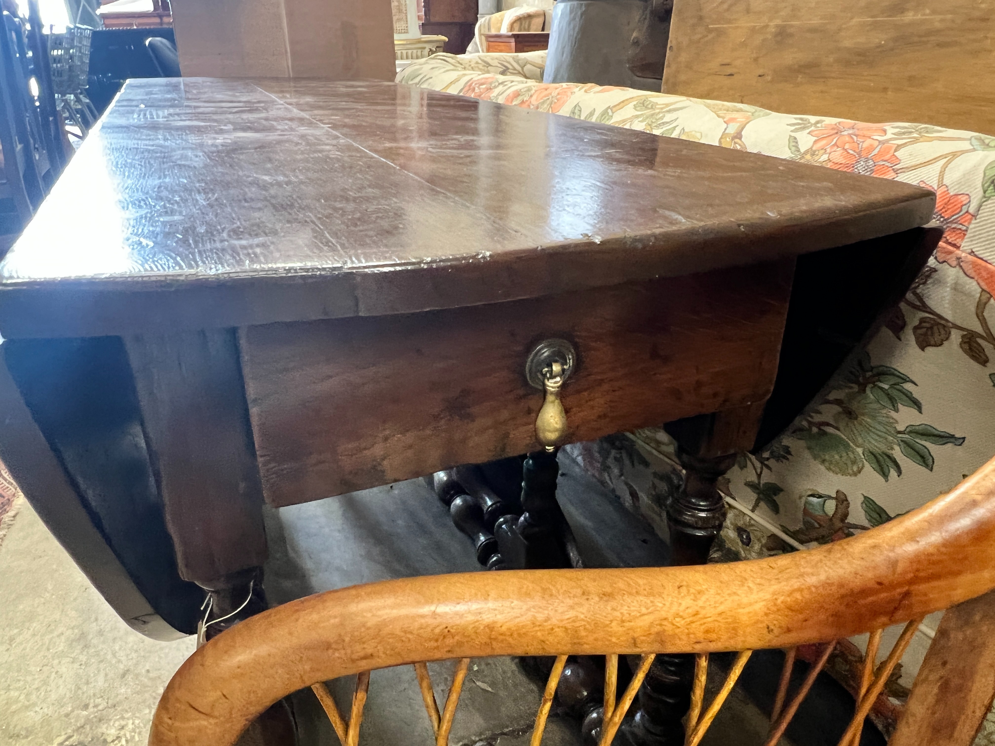 An early 18th century style oak oval topped gateleg dining table, (one leaf in need of repair), length 140cm, width 52cm, height 75cm